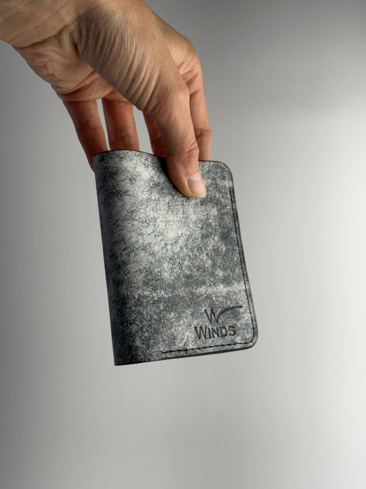 black glance leather wallet front side view with hand and Winds logo on a white background
