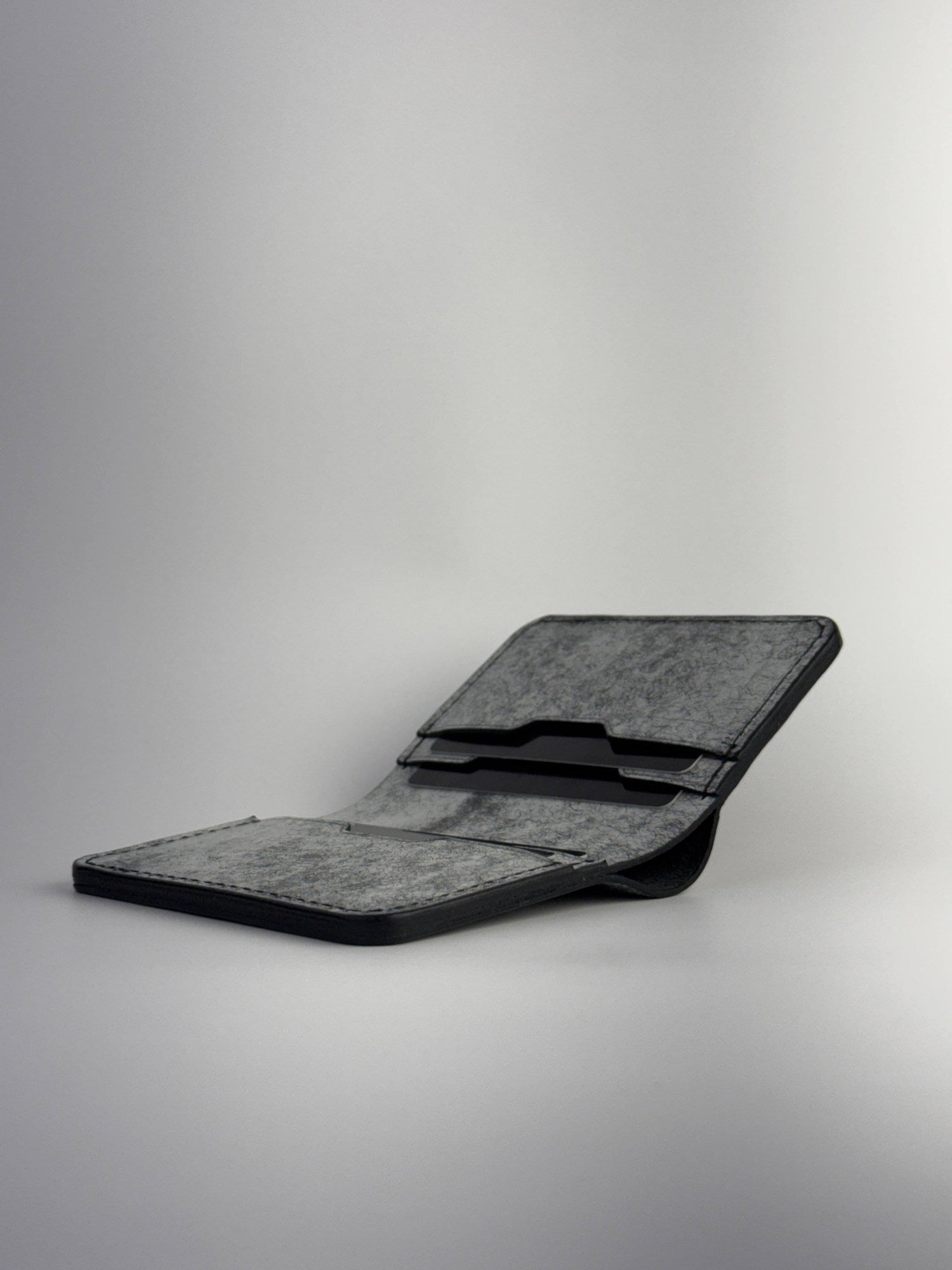 black glance leather wallet lying opened view with cards, on a white background