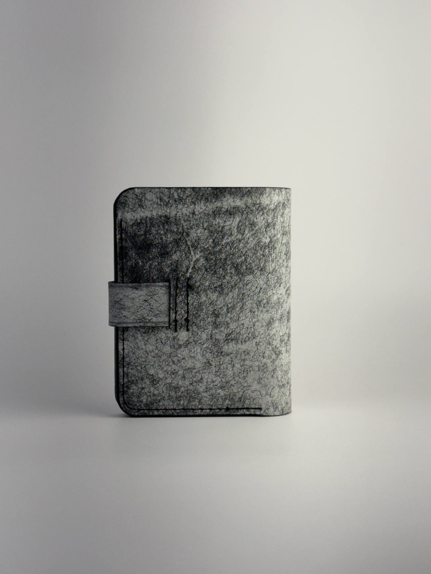 black glance leather wallet with button closure opened front side view with cards and cash on white background