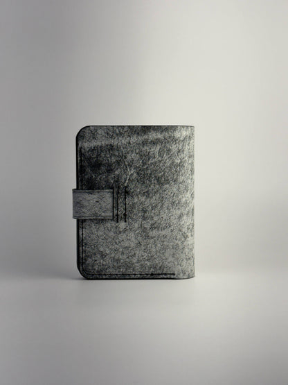 black glance leather wallet with button closure opened front side view with cards and cash on white background