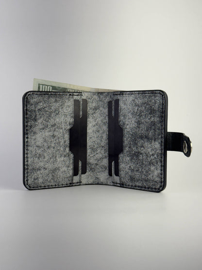 black glance leather wallet with button closure opened front side view with cards and cash on white background