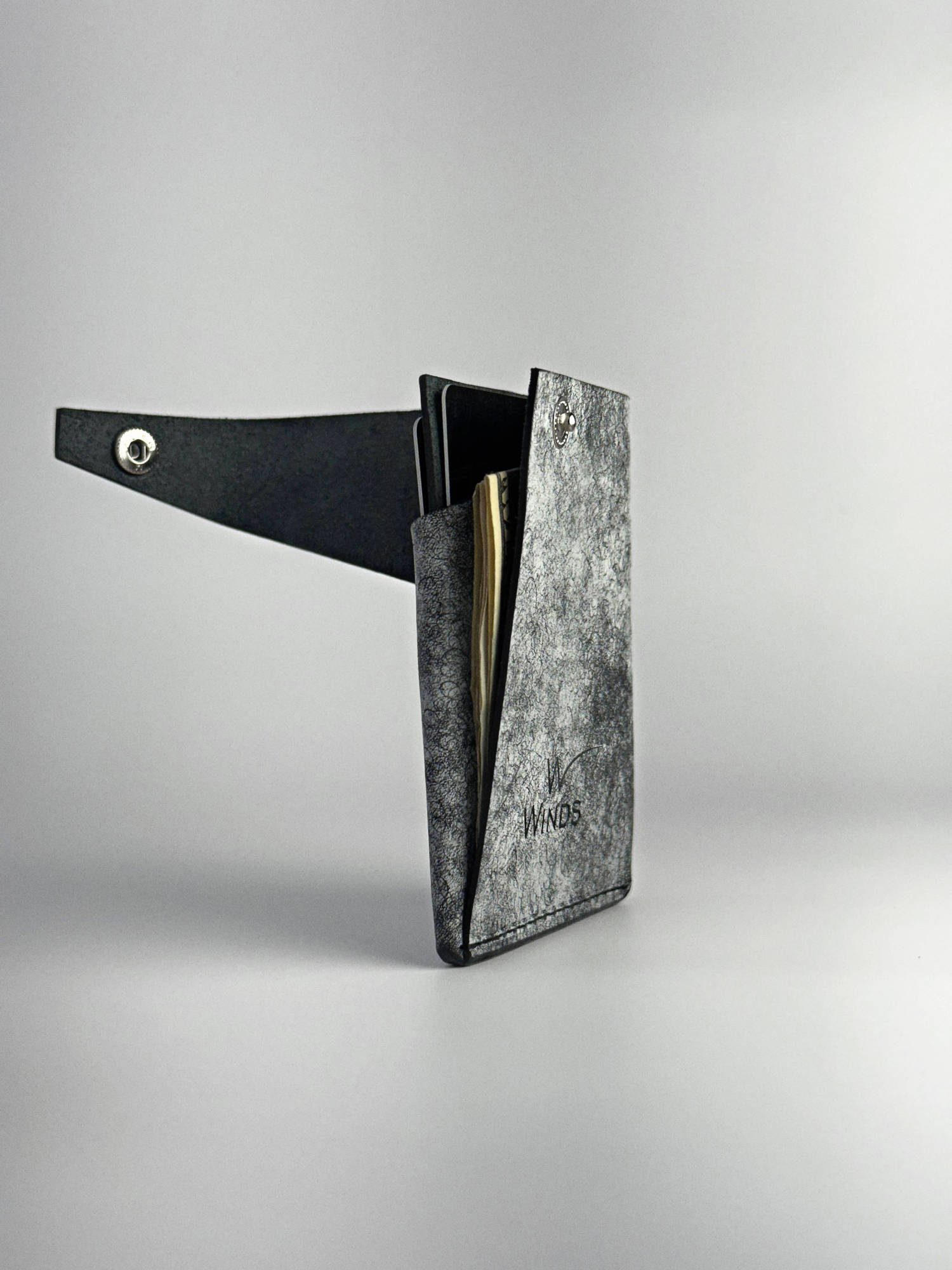 black keeper leather wallet opened rotated edge side view on a white background