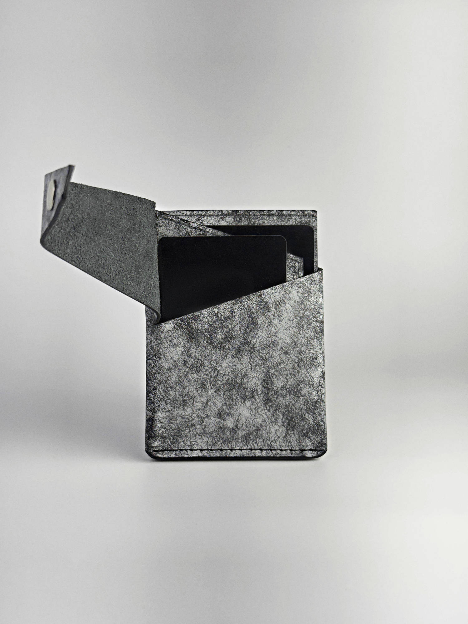 black keeper leather wallet opened with cards front side view on a white background