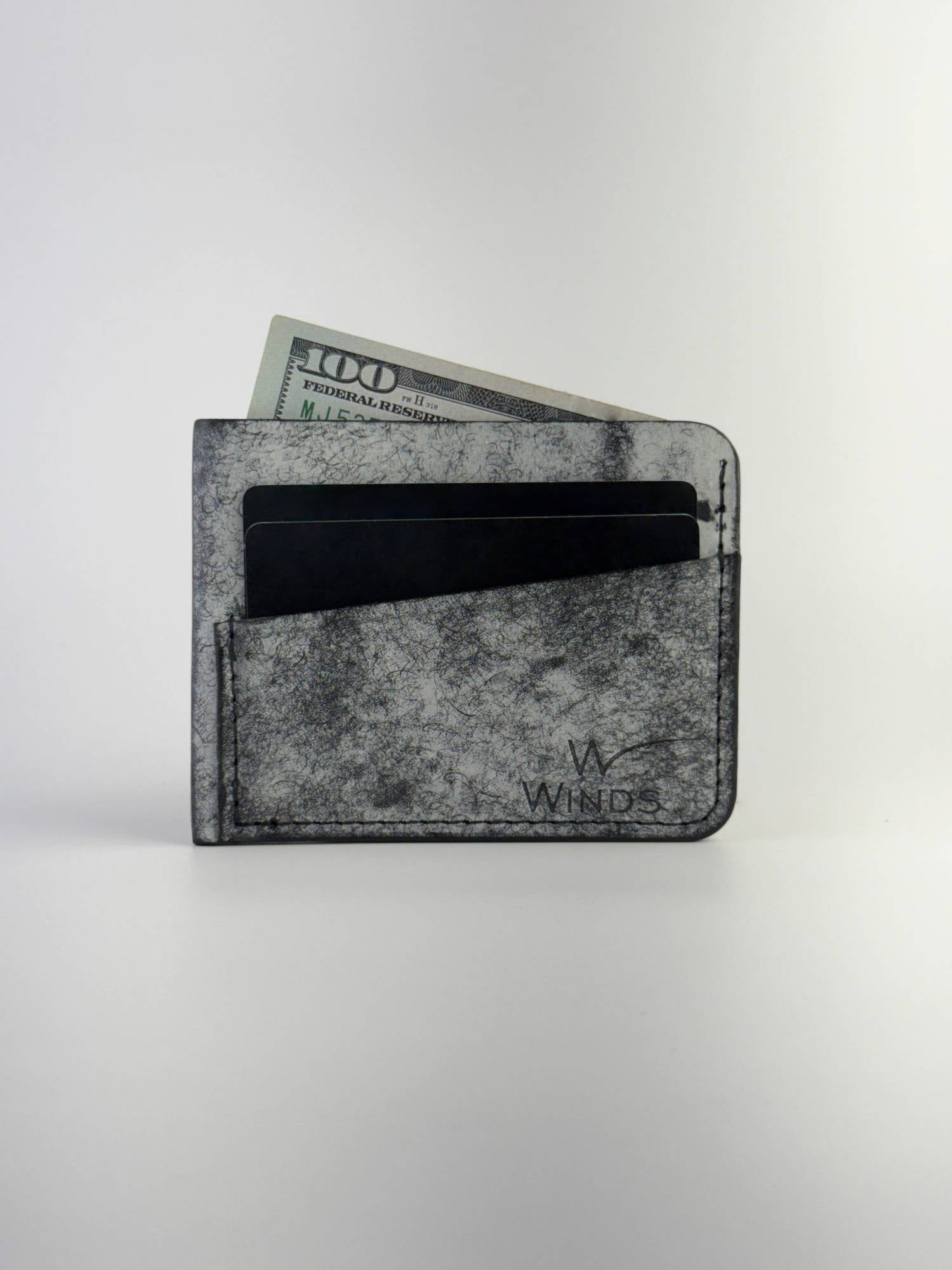 black wing leather cardholder front side with cards, cash and Winds logo, on a white background