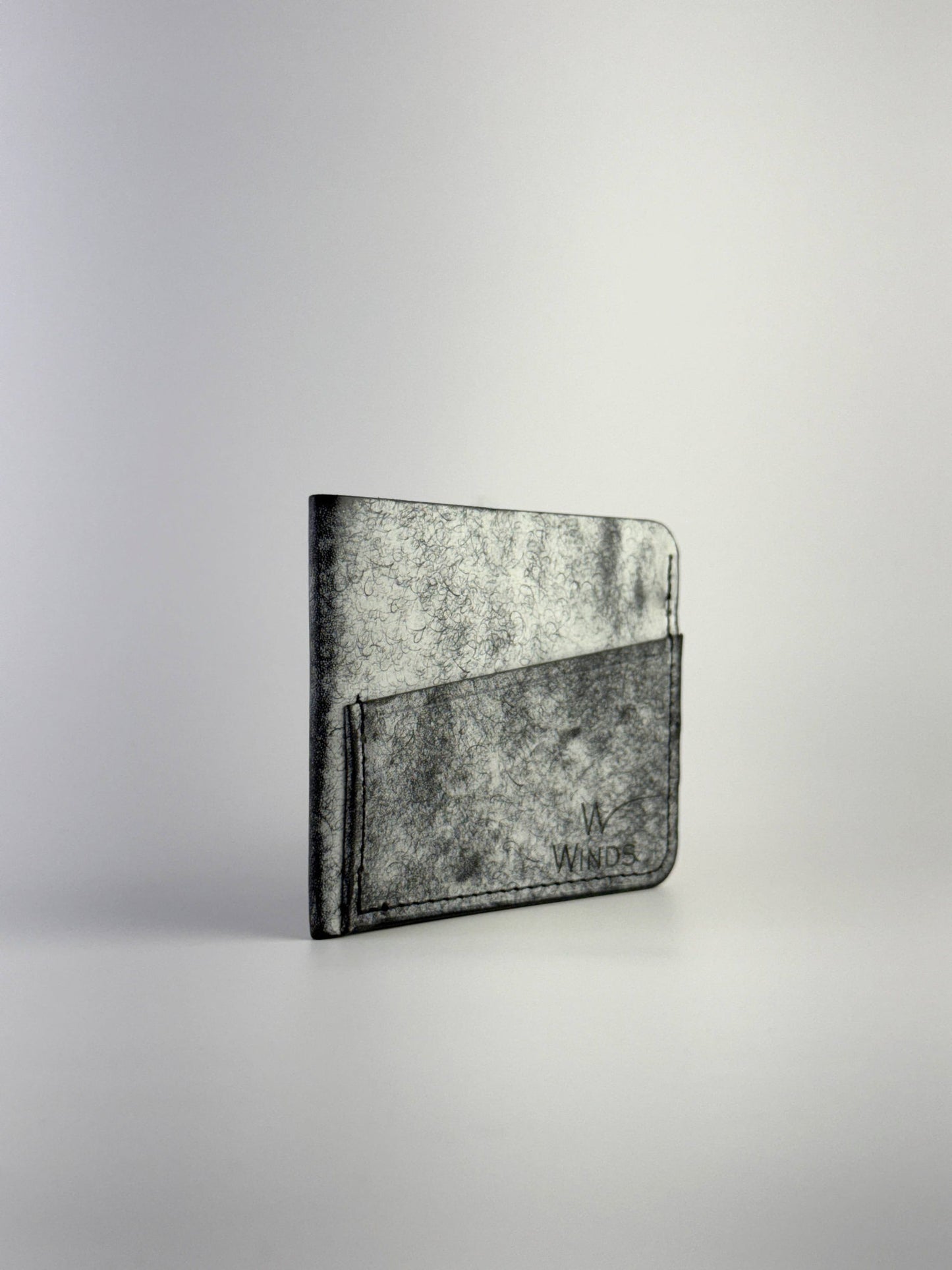 black wing leather cardholder rotated front side with Winds logo, on a white background