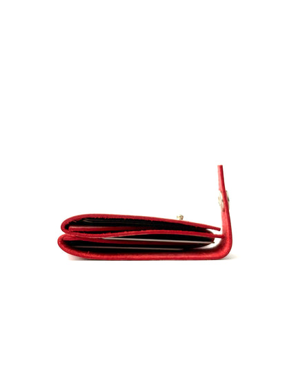 red keeper leather wallet laying and opened with cash and cards
